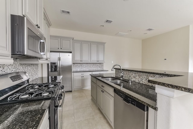 162 Cheswood Forest Pl, Montgomery, TX 77316 - kitchen with appliances with stainless steel finishes, a sink, decorative backsplash, dark stone countertops, and light tile patterned floors