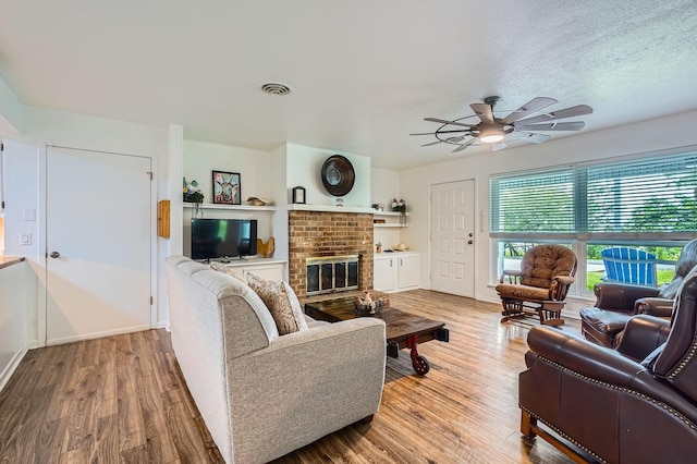 131 Park Dr, Point Blank, TX 77364 - living area with a ceiling fan, wood finished floors, and a brick fireplace