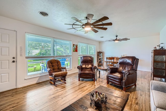 131 Park Dr, Point Blank, TX 77364 - living area with wood-type flooring, a ceiling fan, plenty of natural light, baseboards, and a textured ceiling