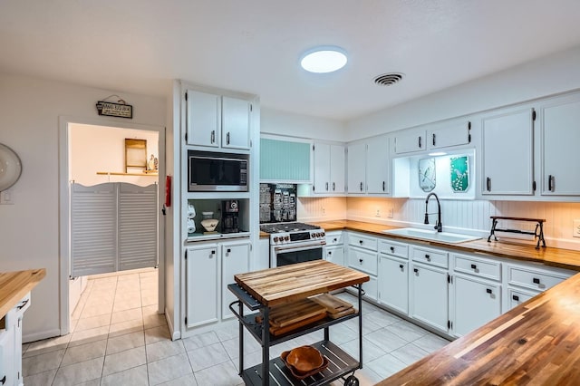 131 Park Dr, Point Blank, TX 77364 - kitchen with built in microwave, a sink, wood counters, gas stove, and light tile patterned floors