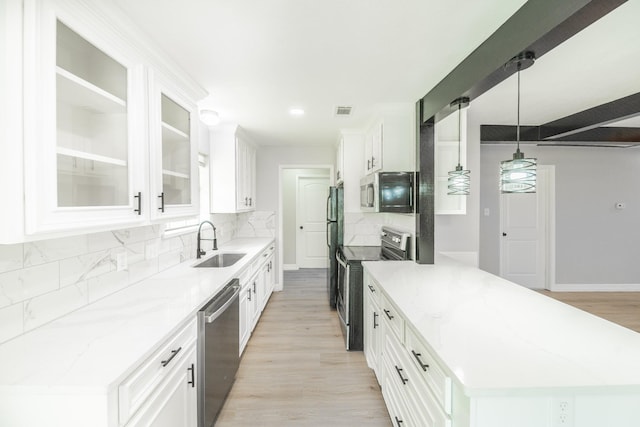 603 W Dallas St, Conroe, TX 77301 - kitchen featuring stainless steel appliances, a sink, tasteful backsplash, white cabinetry, and glass insert cabinets