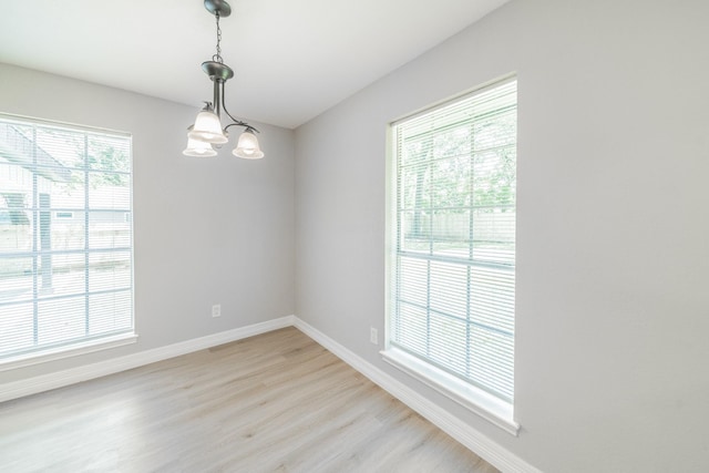 603 W Dallas St, Conroe, TX 77301 - spare room featuring baseboards, light wood finished floors, and a chandelier