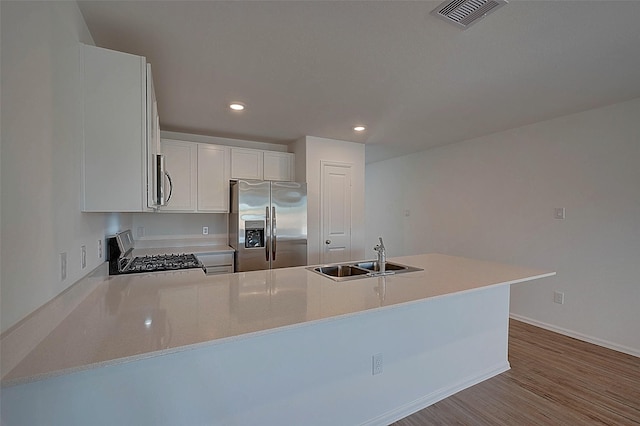 19915 Epirus Shores Dr, Hockley, TX 77447 - kitchen with appliances with stainless steel finishes, a sink, a peninsula, light countertops, and recessed lighting