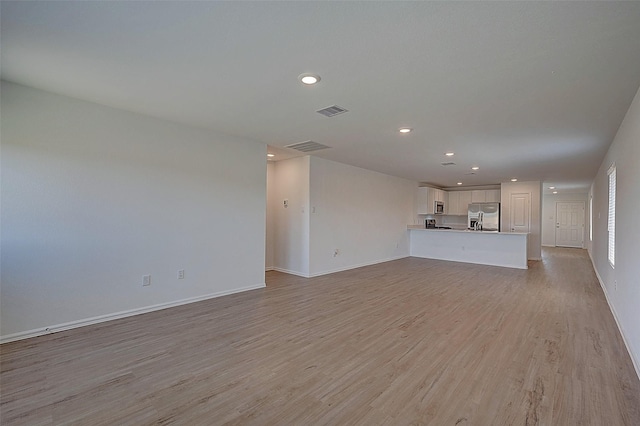 19915 Epirus Shores Dr, Hockley, TX 77447 - unfurnished living room with light wood finished floors, baseboards, and recessed lighting