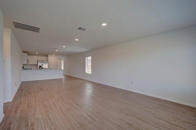 19915 Epirus Shores Dr, Hockley, TX 77447 - unfurnished living room with light wood-style flooring, baseboards, and recessed lighting