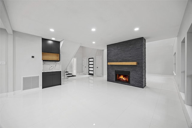 7827 Alamar Dr, Houston, TX 77095 - unfurnished living room with a stone fireplace, stairway, recessed lighting, light tile patterned floors, and baseboards