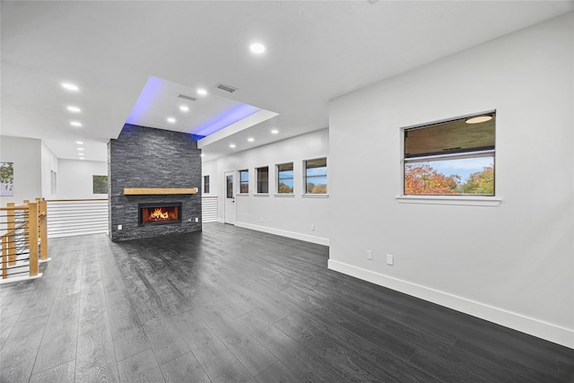7827 Alamar Dr, Houston, TX 77095 - unfurnished living room featuring recessed lighting, baseboards, dark wood-type flooring, a stone fireplace, and a tray ceiling