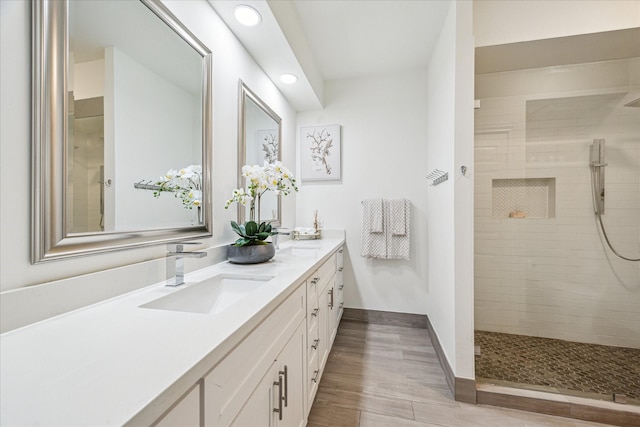 651 Bering Dr Unit 906, Houston, TX 77057 - full bath with double vanity, tiled shower, recessed lighting, baseboards, and wood finished floors