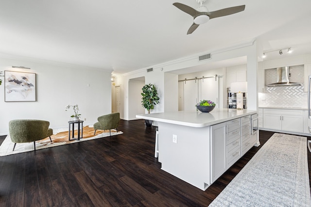 651 Bering Dr Unit 906, Houston, TX 77057 - kitchen with wall chimney range hood, dark wood-type flooring, tasteful backsplash, white cabinetry, and light countertops