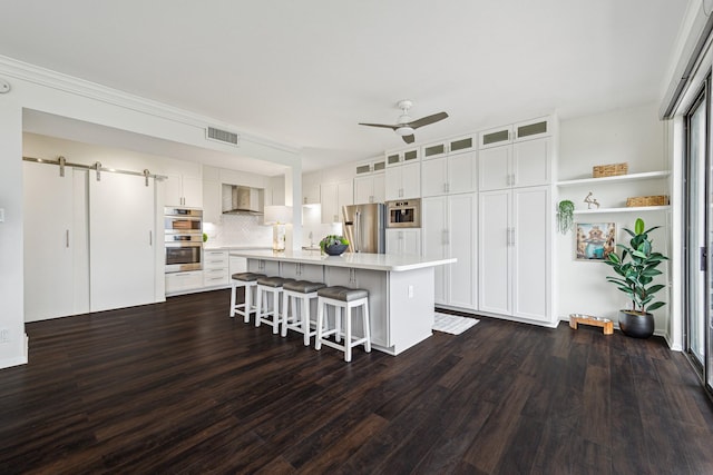 651 Bering Dr Unit 906, Houston, TX 77057 - kitchen featuring appliances with stainless steel finishes, a barn door, light countertops, dark wood-style flooring, and ceiling fan