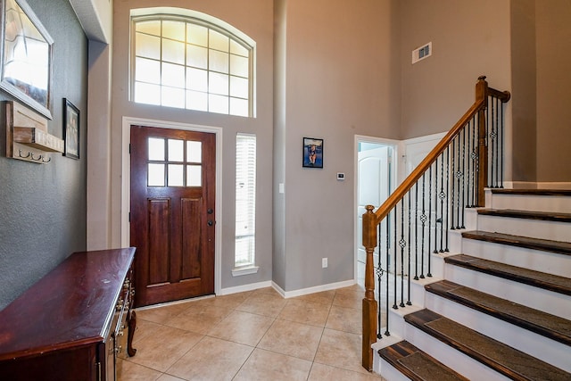 3544 Woods Estates Dr, Conroe, TX 77304 - foyer entrance featuring a towering ceiling, light tile patterned floors, stairs, and baseboards
