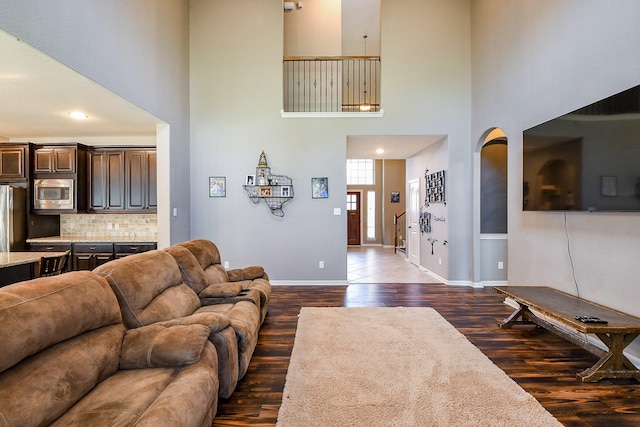 3544 Woods Estates Dr, Conroe, TX 77304 - living room featuring dark wood finished floors, a towering ceiling, and baseboards