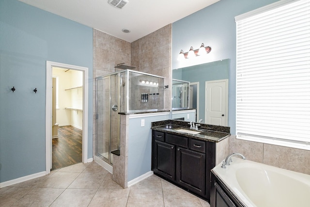 3544 Woods Estates Dr, Conroe, TX 77304 - full bath with a stall shower, vanity, a garden tub, tile patterned floors, and baseboards