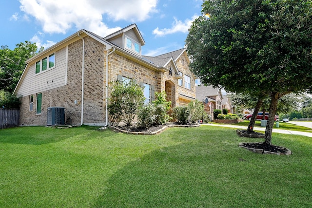 3544 Woods Estates Dr, Conroe, TX 77304 - view of side of home featuring central AC, brick siding, and a yard