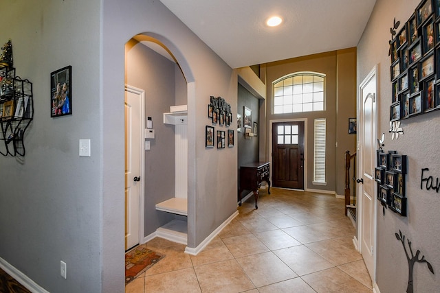 3544 Woods Estates Dr, Conroe, TX 77304 - foyer entrance featuring arched walkways, light tile patterned flooring, and baseboards