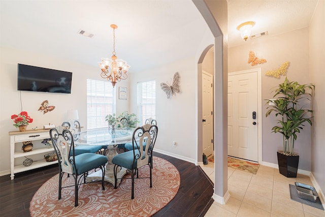 2238 Sterling Oaks Dr, Rosharon, TX 77583 - dining area featuring arched walkways, a chandelier, wood finished floors, and baseboards