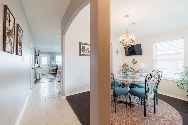 2238 Sterling Oaks Dr, Rosharon, TX 77583 - dining space with arched walkways, a chandelier, baseboards, and wood finished floors