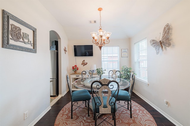 2238 Sterling Oaks Dr, Rosharon, TX 77583 - dining space featuring arched walkways, a chandelier, dark wood-type flooring, and baseboards