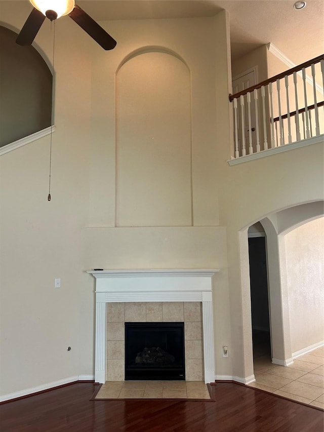 6015 Biltmore Ct, Rosenberg, TX 77471 - detailed view of ceiling fan, wood finished floors, a tile fireplace, arched walkways, and baseboards