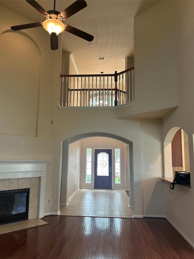 6015 Biltmore Ct, Rosenberg, TX 77471 - entrance foyer featuring baseboards, wood-type flooring, a ceiling fan, a high ceiling, and a tile fireplace