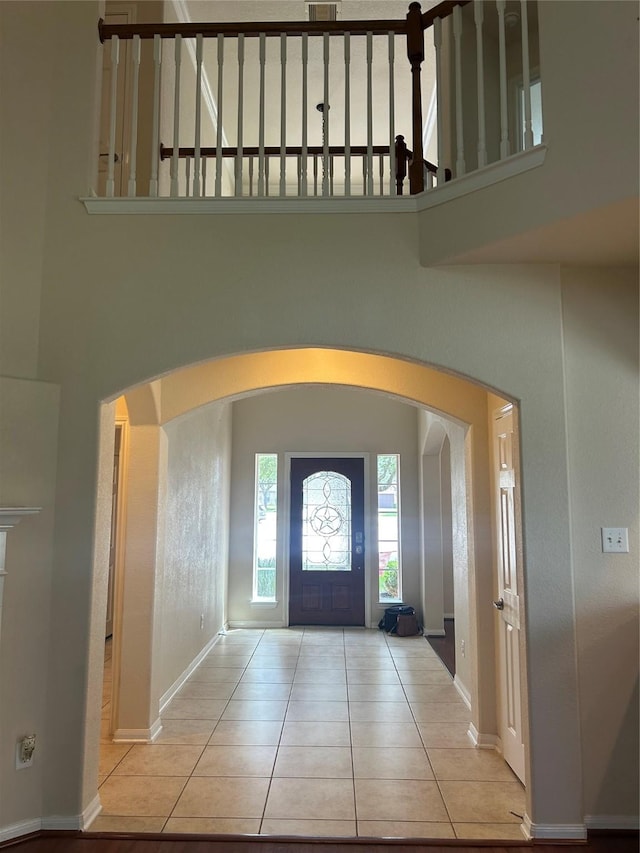 6015 Biltmore Ct, Rosenberg, TX 77471 - tiled foyer entrance featuring arched walkways, baseboards, and a high ceiling