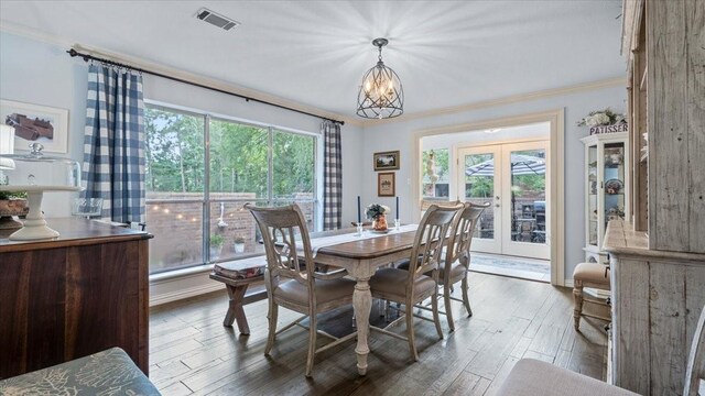 1925 Foxbriar Dr, Huntsville, TX 77340 - dining room featuring french doors, crown molding, a chandelier, wood finished floors, and baseboards