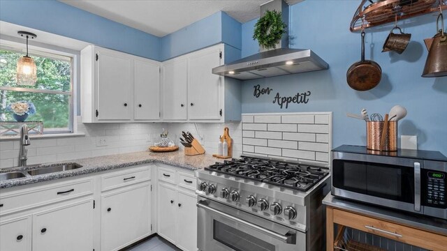 1925 Foxbriar Dr, Huntsville, TX 77340 - kitchen with appliances with stainless steel finishes, wall chimney range hood, a sink, and backsplash