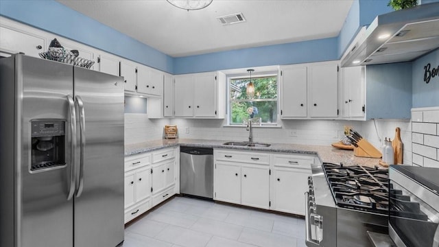 1925 Foxbriar Dr, Huntsville, TX 77340 - kitchen featuring stainless steel appliances, a sink, exhaust hood, white cabinets, and tasteful backsplash