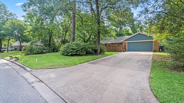 1925 Foxbriar Dr, Huntsville, TX 77340 - view of front of house with driveway, a front yard, a garage, and brick siding