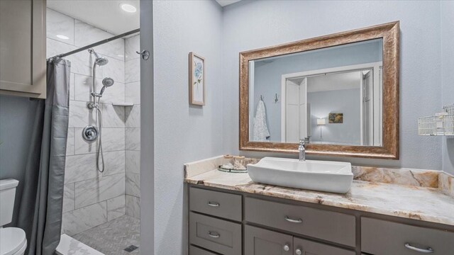1925 Foxbriar Dr, Huntsville, TX 77340 - bathroom with toilet, vanity, tiled shower, and a textured wall
