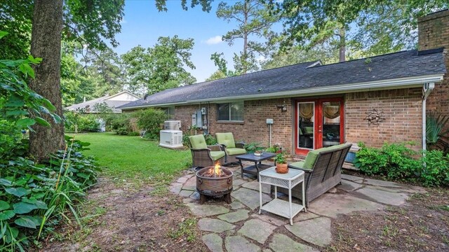 1925 Foxbriar Dr, Huntsville, TX 77340 - rear view of house with a fire pit, a yard, brick siding, and a patio area