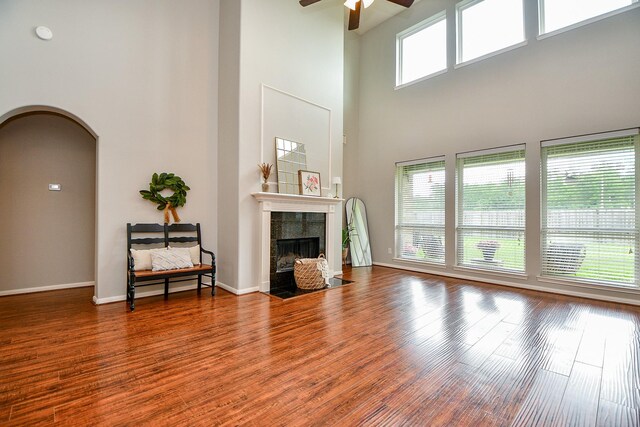 1638 Brookstone Ln, Sugar Land, TX 77479 - living area with a ceiling fan, a towering ceiling, arched walkways, a tile fireplace, and wood finished floors