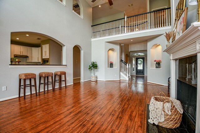 1638 Brookstone Ln, Sugar Land, TX 77479 - living area featuring a ceiling fan, a high ceiling, wood finished floors, baseboards, and stairs