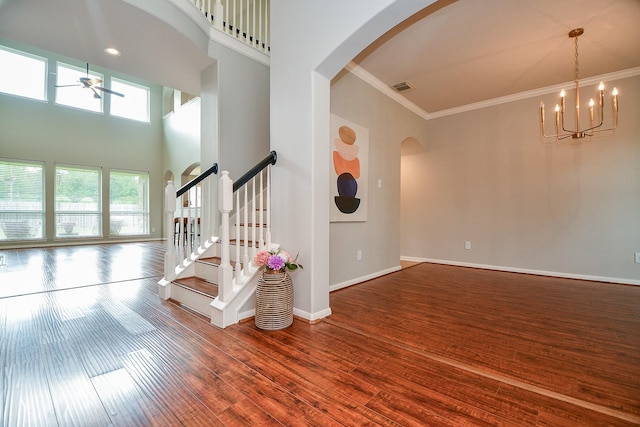 1638 Brookstone Ln, Sugar Land, TX 77479 - staircase with arched walkways, a ceiling fan, ornamental molding, wood finished floors, and baseboards