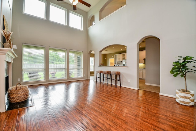 1638 Brookstone Ln, Sugar Land, TX 77479 - living area with ceiling fan, a towering ceiling, wood finished floors, baseboards, and a premium fireplace