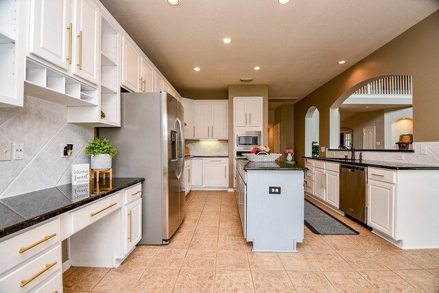 1638 Brookstone Ln, Sugar Land, TX 77479 - kitchen featuring appliances with stainless steel finishes, open shelves, arched walkways, recessed lighting, and decorative backsplash