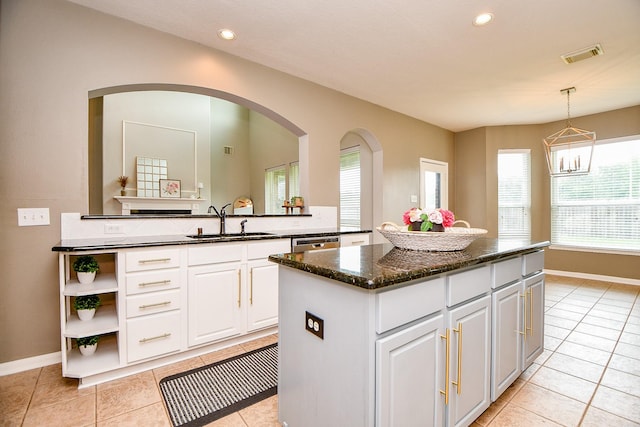 1638 Brookstone Ln, Sugar Land, TX 77479 - kitchen featuring a sink, a center island, light tile patterned floors, white cabinets, and baseboards