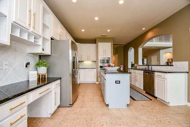 1638 Brookstone Ln, Sugar Land, TX 77479 - kitchen with appliances with stainless steel finishes, open shelves, recessed lighting, arched walkways, and backsplash