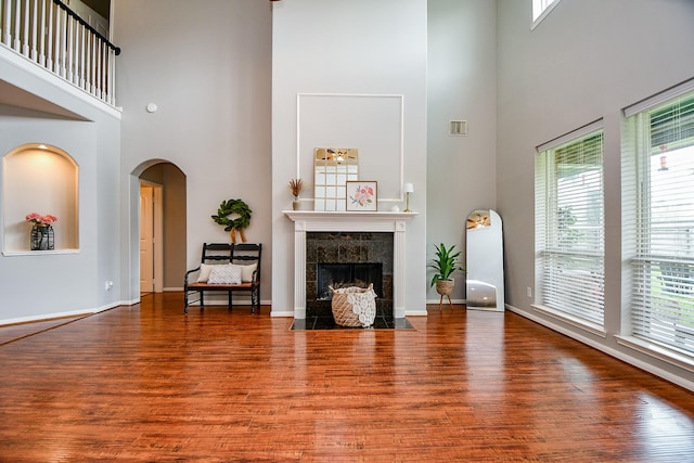 1638 Brookstone Ln, Sugar Land, TX 77479 - living room with a high ceiling, wood finished floors, arched walkways, and a tiled fireplace