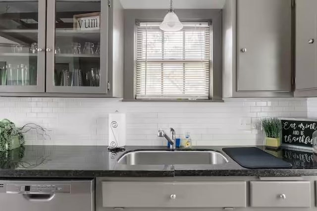1017 Milner, College Station, TX 77840 - kitchen featuring stainless steel dishwasher, a sink, glass insert cabinets, backsplash, and dark stone counters
