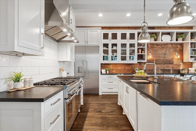 523 E 23rd St, Houston, TX 77008 - kitchen featuring premium appliances, wall chimney range hood, dark countertops, and recessed lighting