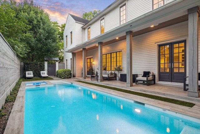 523 E 23rd St, Houston, TX 77008 - pool at dusk featuring outdoor lounge area, a pool with connected hot tub, and french doors