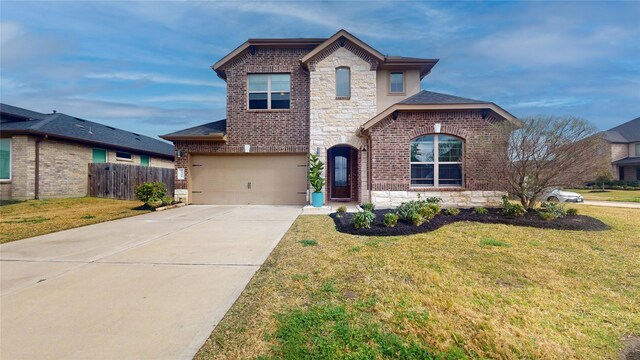 3539 Gore Creek Dr, Katy, TX 77494 - french country inspired facade with brick siding, stone siding, concrete driveway, and a garage