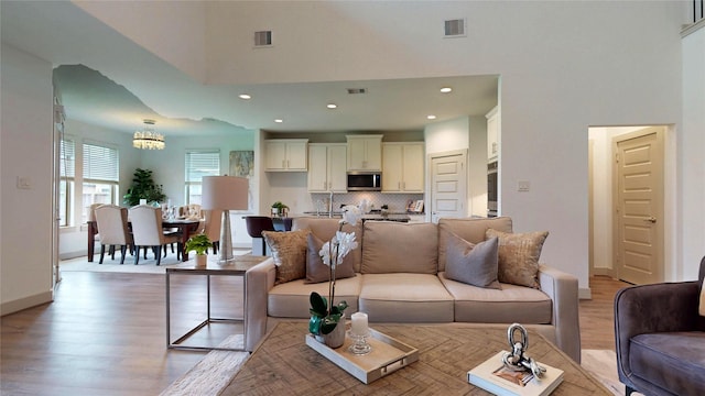 3539 Gore Creek Dr, Katy, TX 77494 - living area with a high ceiling, light wood-type flooring, a chandelier, recessed lighting, and baseboards