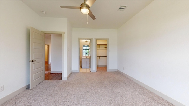 3539 Gore Creek Dr, Katy, TX 77494 - unfurnished bedroom featuring carpet floors, a walk in closet, a ceiling fan, a closet, and baseboards