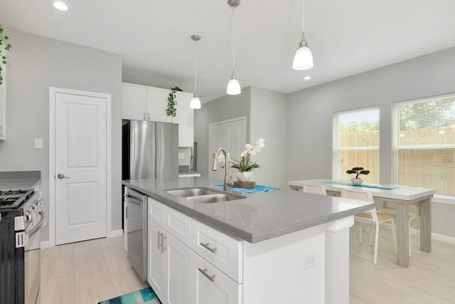 414 Armstrong St, Houston, TX 77029 - kitchen featuring stainless steel appliances, a sink, baseboards, white cabinetry, and an island with sink