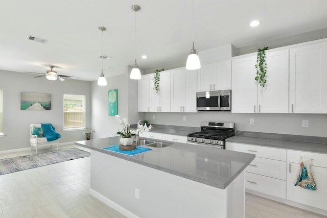 414 Armstrong St, Houston, TX 77029 - kitchen featuring stainless steel appliances, white cabinetry, open floor plan, recessed lighting, and a sink