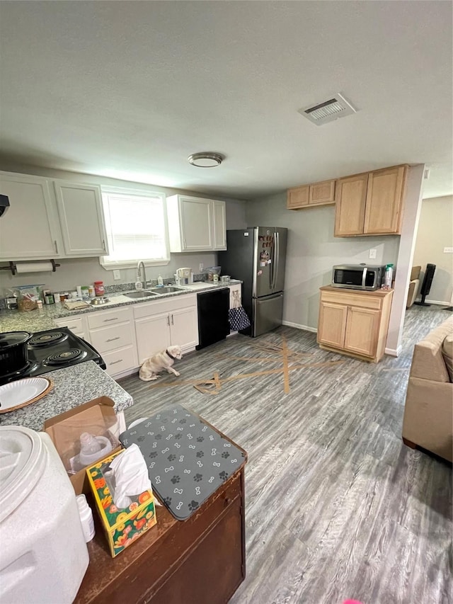 103 Prewitt Ln, West Columbia, TX 77486 - kitchen with black appliances, a sink, wood finished floors, light countertops, and baseboards