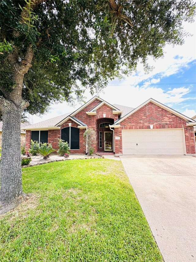 4306 Dow Way, Pasadena, TX 77505 - ranch-style home with an attached garage, brick siding, driveway, and a front lawn