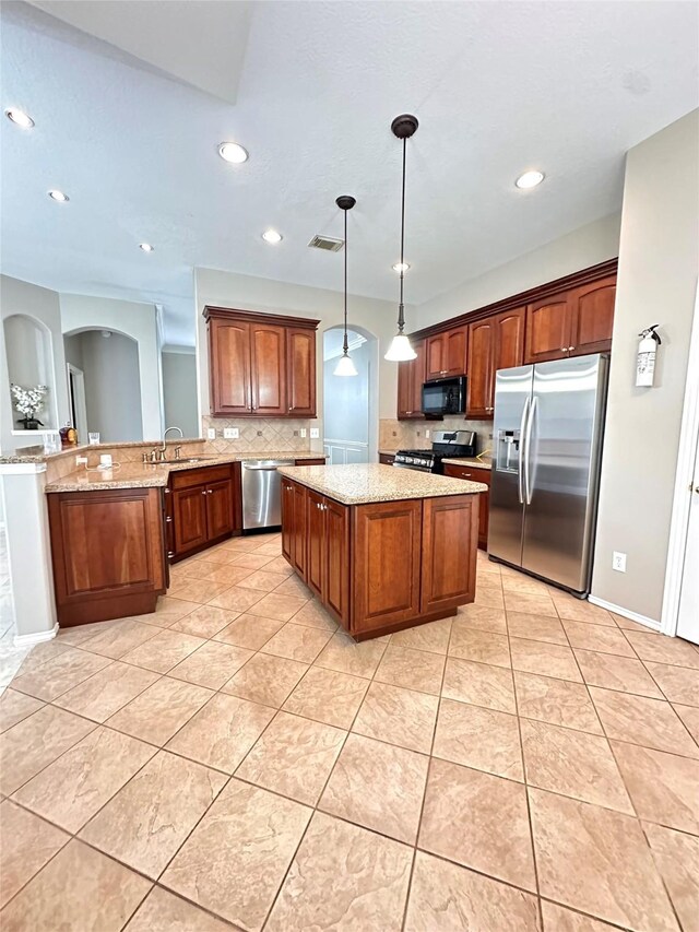 4306 Dow Way, Pasadena, TX 77505 - kitchen with appliances with stainless steel finishes, backsplash, a peninsula, light stone counters, and a kitchen island